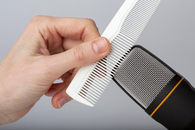 Person using comb close to microphone for asmr