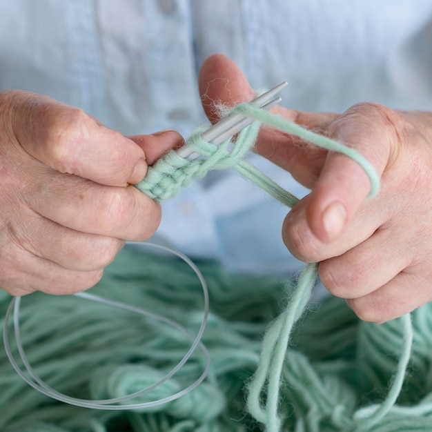 Free photo person using crochet needles and yarn