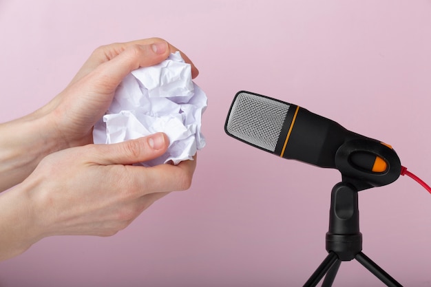 Person using crumpled paper close to microphone for asmr