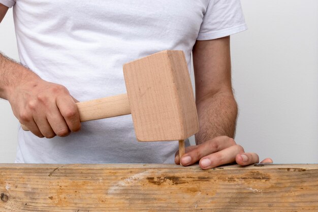 Person using a hammer made out of wood