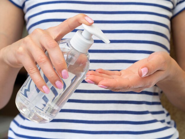 Person using hand sanitizer from plastic bottle