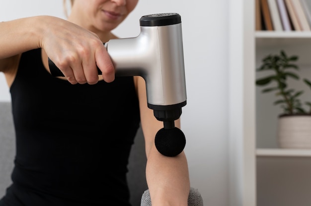 Free photo person using massage gun