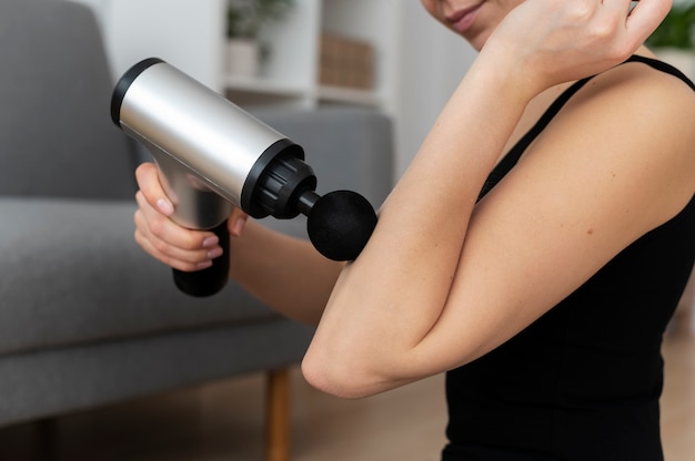 Free photo person using massage gun