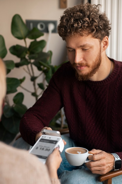 Foto gratuita persona che utilizza la tecnologia nfc per pagare il conto in un ristorante