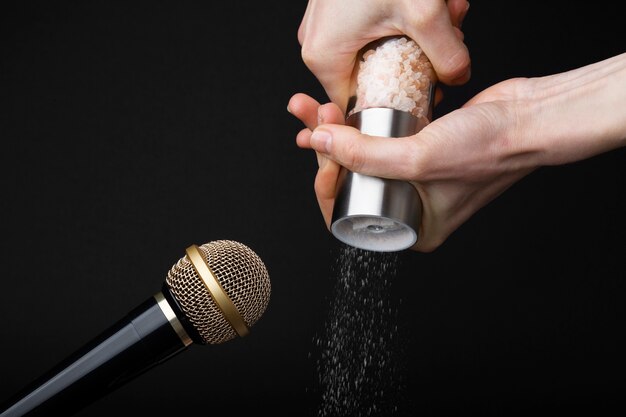 Person using salt grinder close to microphone for asmr