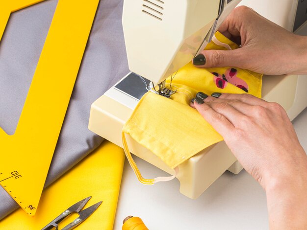 Person using sewing machine for face masks