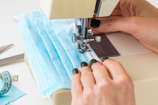 Person using sewing machine for medical mask