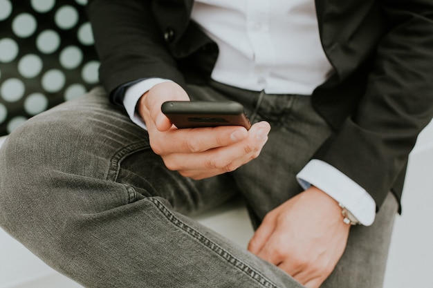 Person using a smartphone to check social media while sitting on the couch