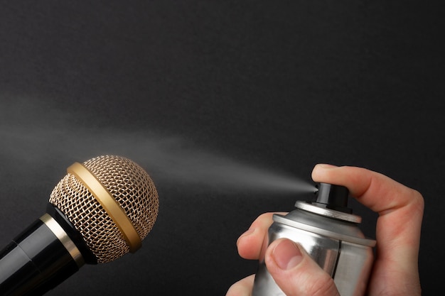 Foto gratuita persona che usa il flacone spray vicino al microfono per asmr