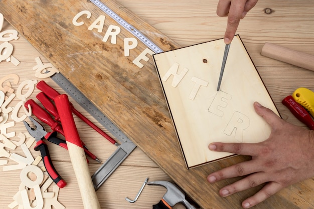 Person using tools to create carpentry word top view