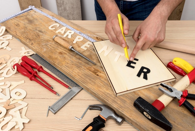 Person using tools to create carpentry word