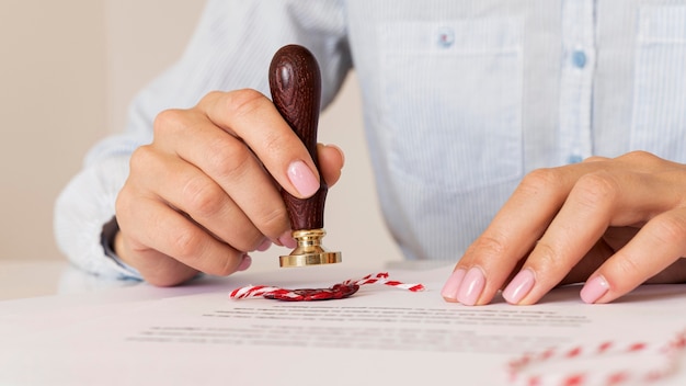 Person using a wax seal blurred certificate