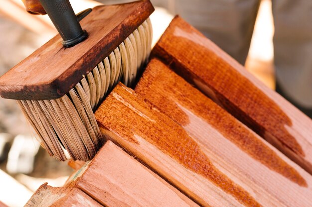 Person varnishing the wood with big brush