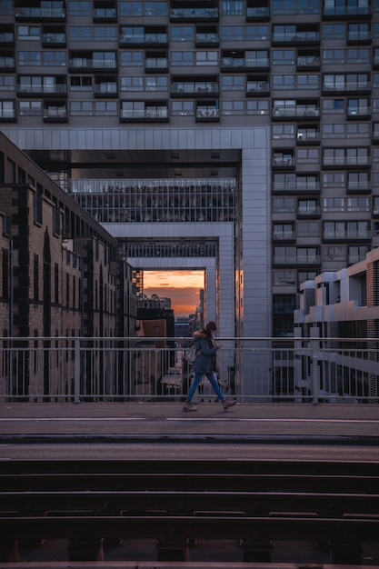 Free photo person walking on bridge at sunset