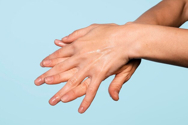 Person washing hands isolated on blue