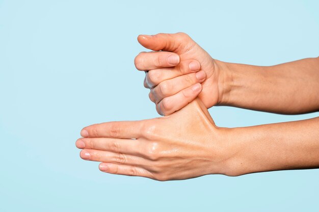 Person washing hands isolated on blue