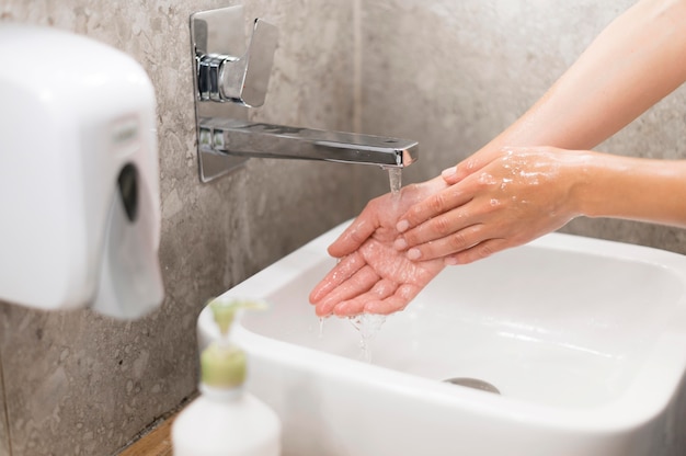Лицо, моющее руки с мылом