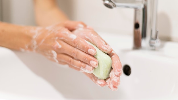 Лицо, моющее руки с мылом