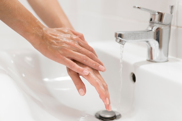 Foto gratuita persona lavarsi le mani con sapone