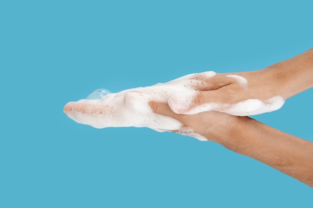 Person washing its hands on blue background