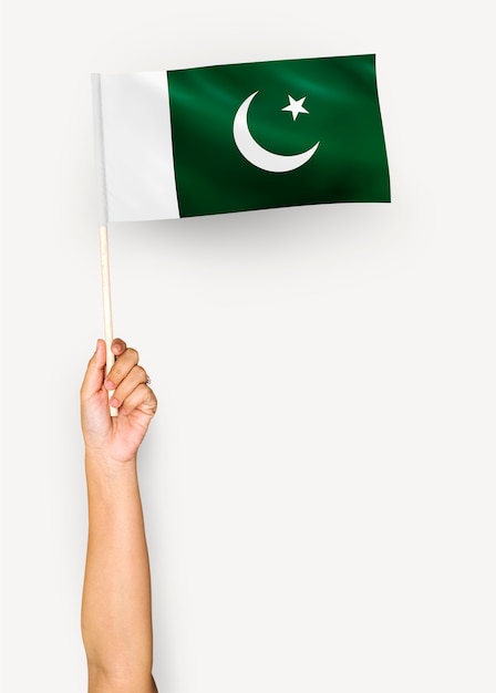 Persona che sventola la bandiera della repubblica islamica del pakistan