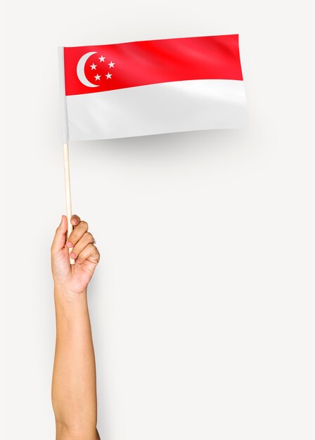 Человек размахивает флагом Республики Сингапур