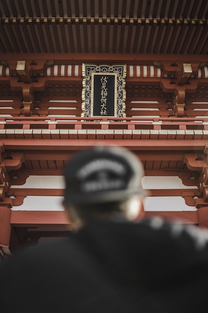 Person wearing black cap in front of tower