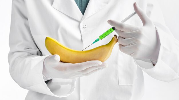 Person wearing gloves injecting a banana