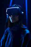 Free photo person wearing high-tech vr glasses while surrounded by bright blue neon colors