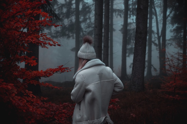 Person wearing white coat and white hat in forest