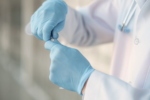 Free photo person in a white uniform holding a ampoule in her hands