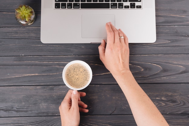 Person with coffee working on laptop at table