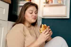 Free photo person with eating disorder trying to eat fast food