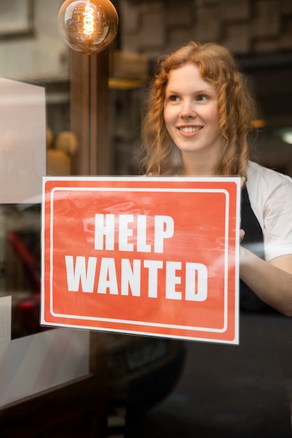 Free photo person with hiring sign by the window