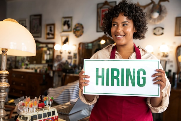 Person with hiring sign by the window