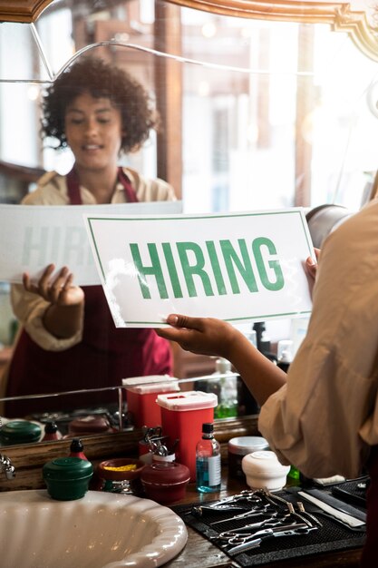 Person with hiring sign by the window