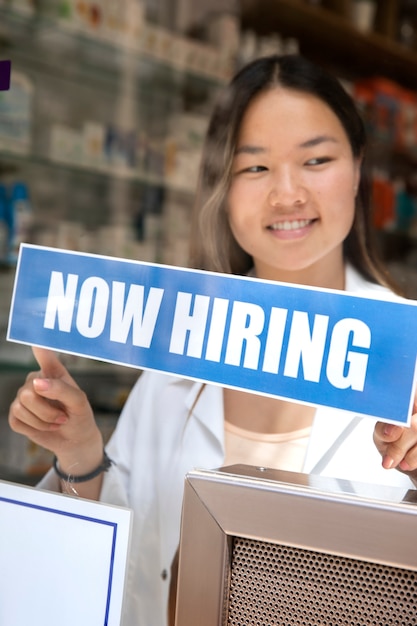 Free photo person with hiring sign by the window