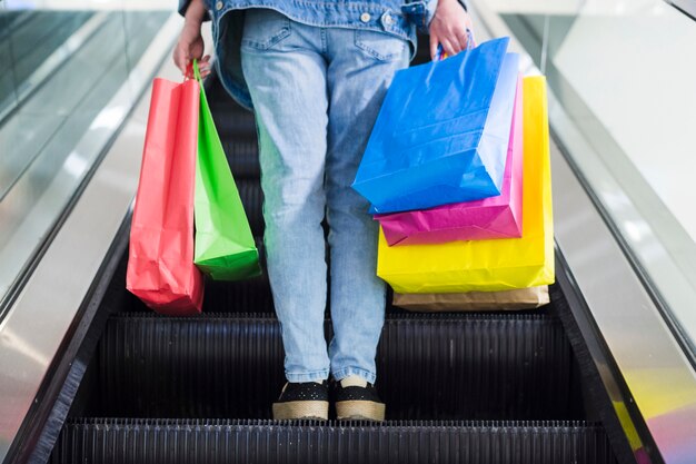 Person with shopping bags on the escalator