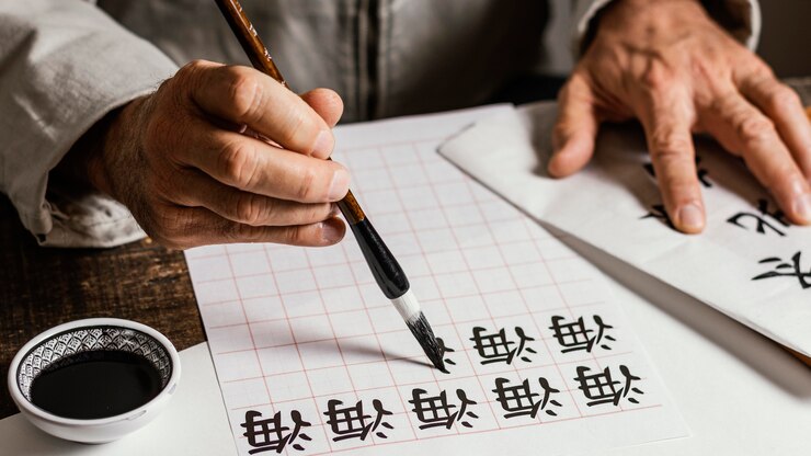 Free Photo person writing chinese symbols on white paper