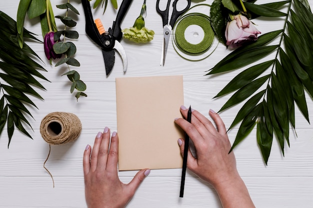 Person writing on florist table