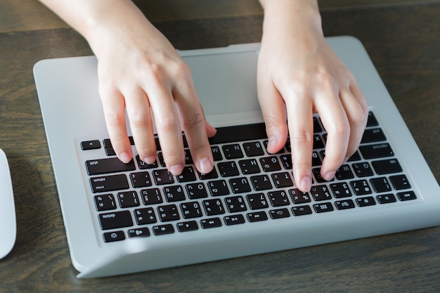 Free photo person writing on a laptop