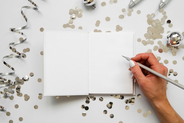 Person writing on a mock-up paper top view