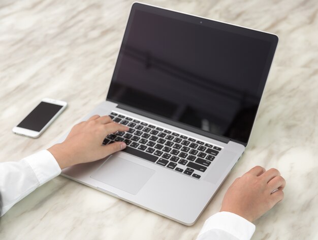 Person writing with one hand and the other touching a mouse