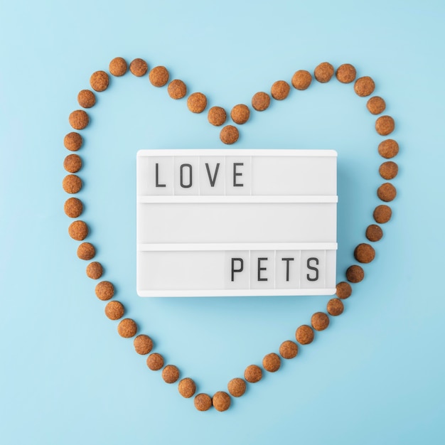 Pet accessories still life concept with dry food in heart shape