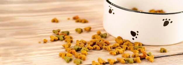 Pet food in a bowl on a wooden vintage background. dry food for dogs or cats in a bowl on a wooden background.