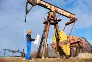 Free photo petroleum engineer controlling work of oil well pump jack