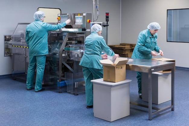 製薬技術者は製薬工場で無菌作業条件で作業します保護服を着た科学者