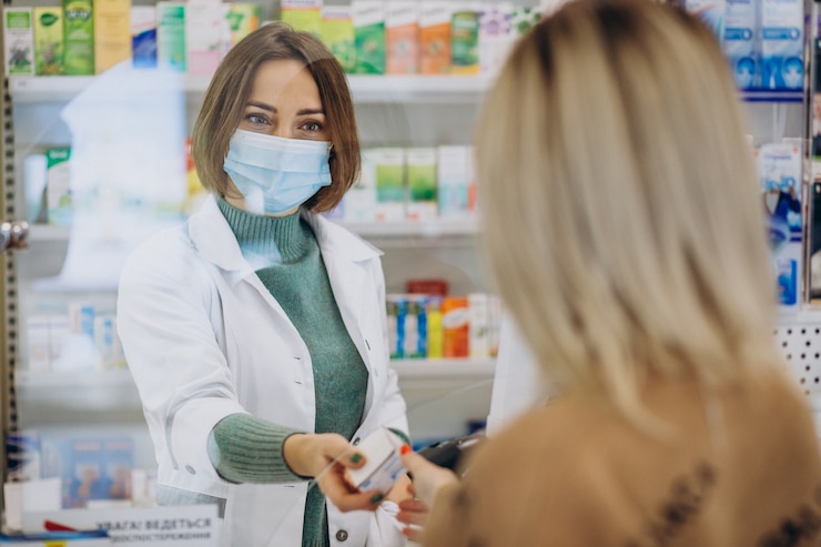 Free Photo pharmasict serving customer at drug store