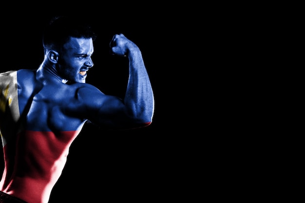 Free photo philippines flag on handsome young muscular man black background