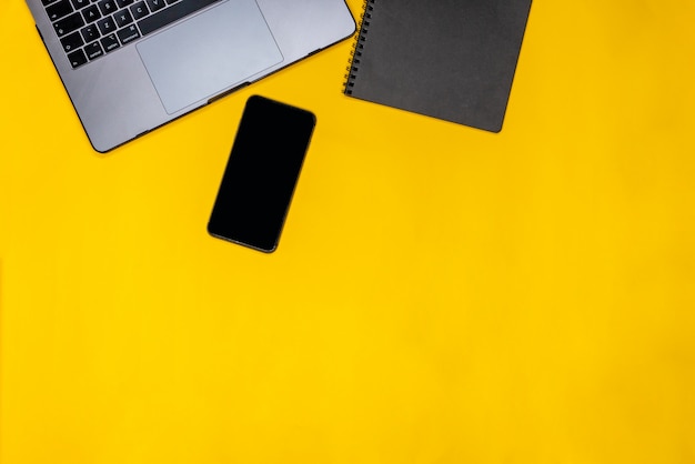 Phone, black notepad and laptop